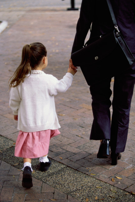 Little girl walking hand in hand with mother