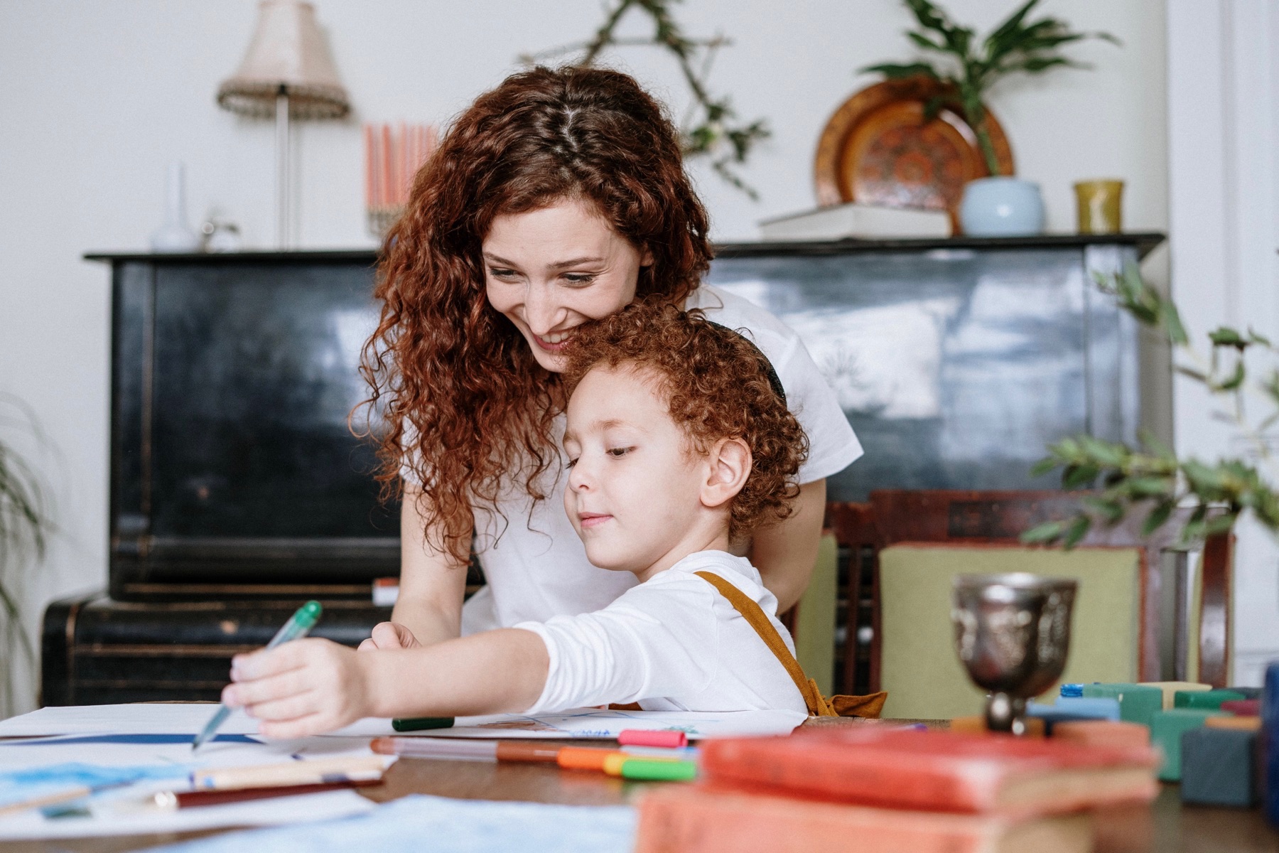 A mother and her child work on an art project together at home.