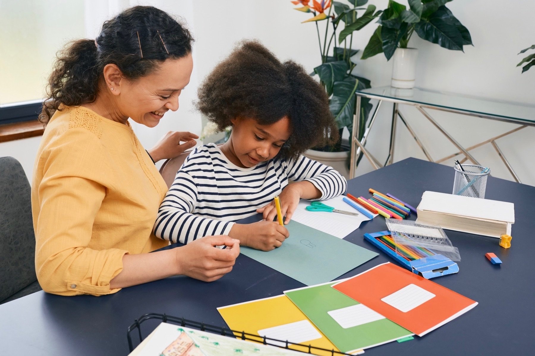 Mom helping daughter with schoolwork. 