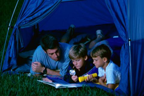 Dad and sons camping in the backyard
