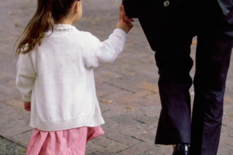 Little girl walking hand in hand with mother