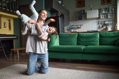 Mom and child playing in the living room of their home.