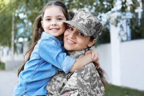 A military mother greets her daughter with a smile.