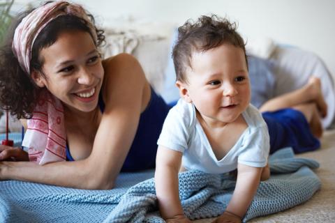 Mom and baby play together on the floor.