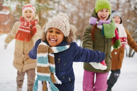A group of children play together in the snow.