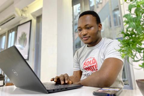 A man does research on his computer while sitting at his desk.