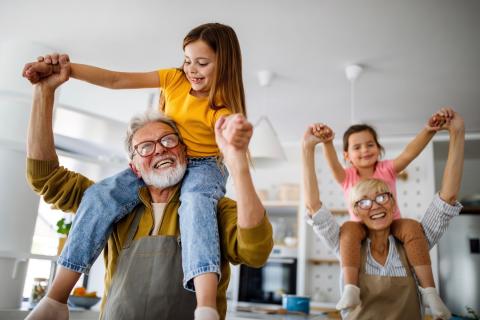 Two happy grandparents playing with their grandchildren.