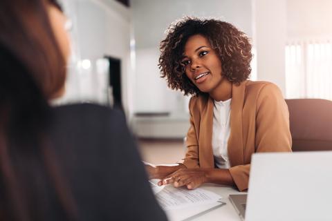 A female family law attorney speaks to a client in her office.