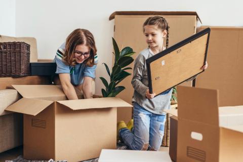 Mom and daughter packing moving boxes.