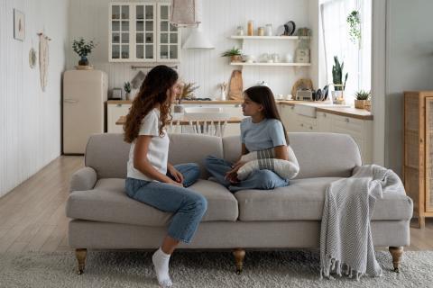 Mom and daughter serious talk on couch.