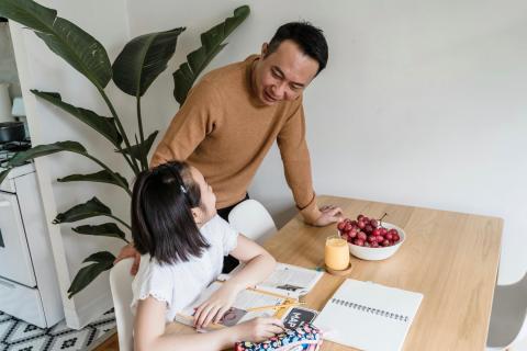 Dad helping daughter with her homework.