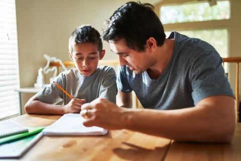 Dad helping young son with homework.