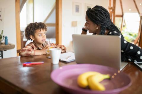 Mom and young daughter talking at table