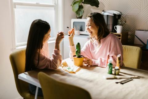 Mom and daughter painting happily.