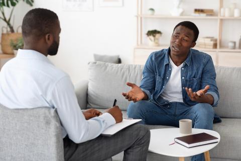 Man having a therapy session with a male therapist.