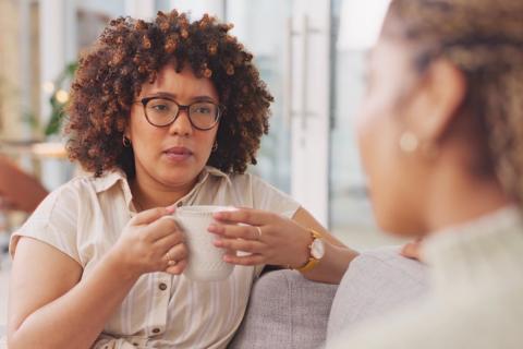 Two women talking seriously on couch