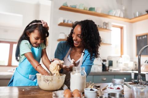 Mom and young daughter baking in the kitchen.