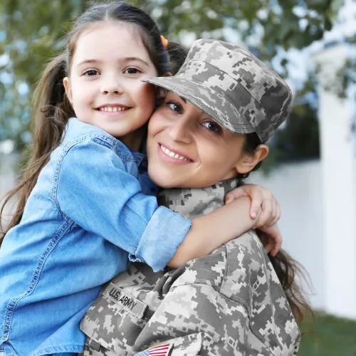 A military mother greets her daughter with a smile.