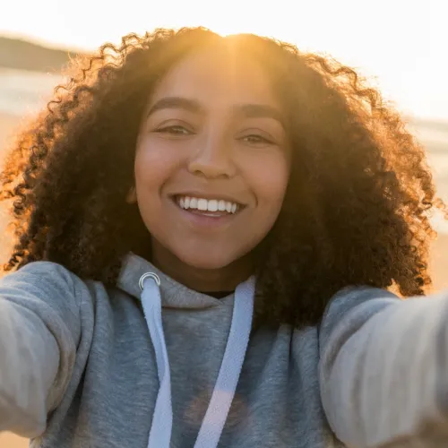 Teenage girl takes a selfie on the beach.