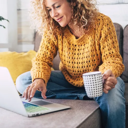 Woman does research on her computer from her living room.