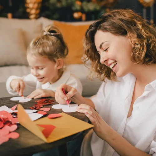 Mom and daughter making paper hearts.
