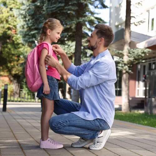 Man dropping his daughter off at school.