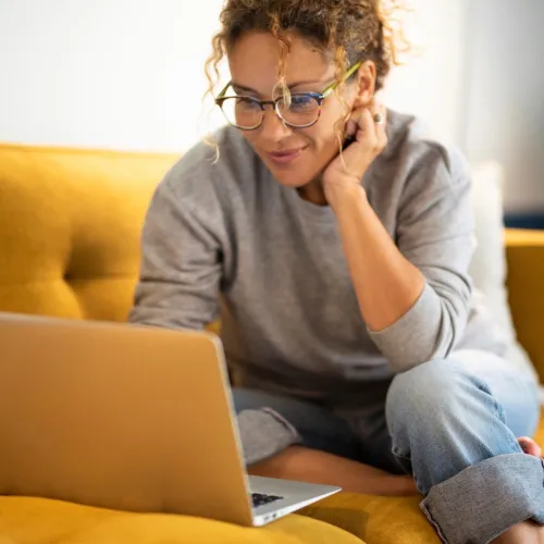 Woman on laptop on couch. 