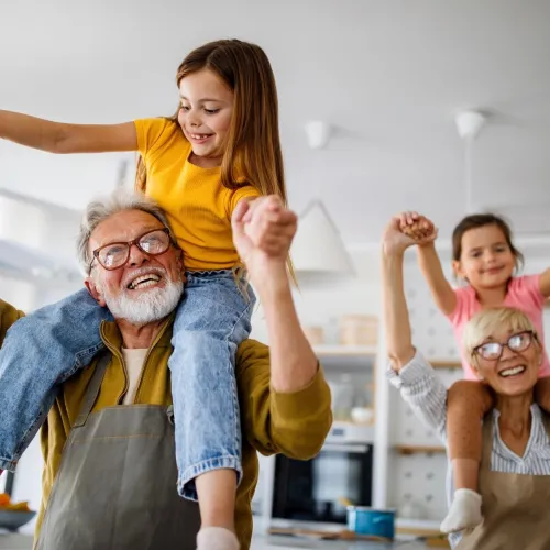 Two happy grandparents playing with their grandchildren.