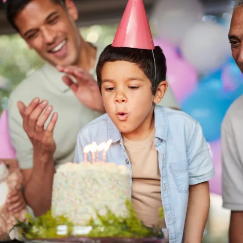 Little boy blowing out birthday candles. 