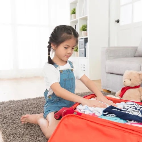 Girl packing a suitcase. 