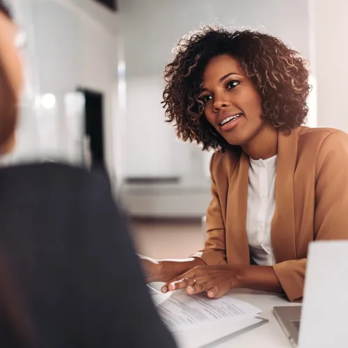A female family law attorney speaks to a client in her office.