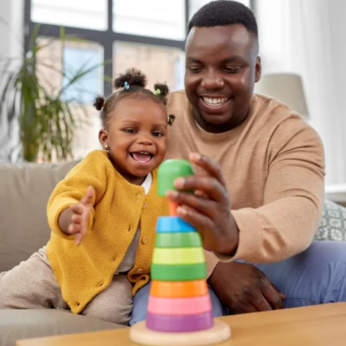 Dad and daughter playing with a ring toy. 