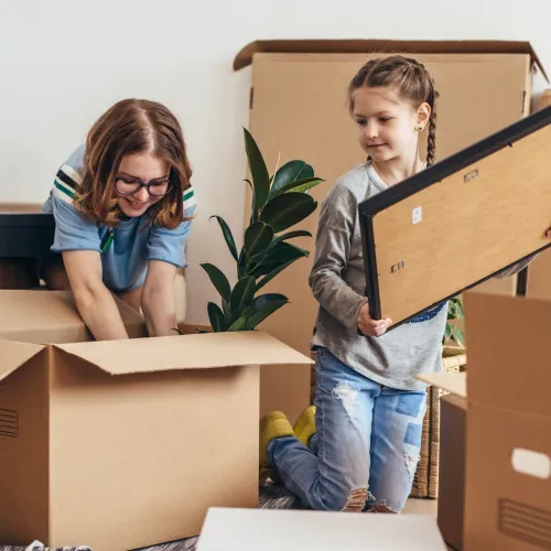 Mom and daughter packing moving boxes.