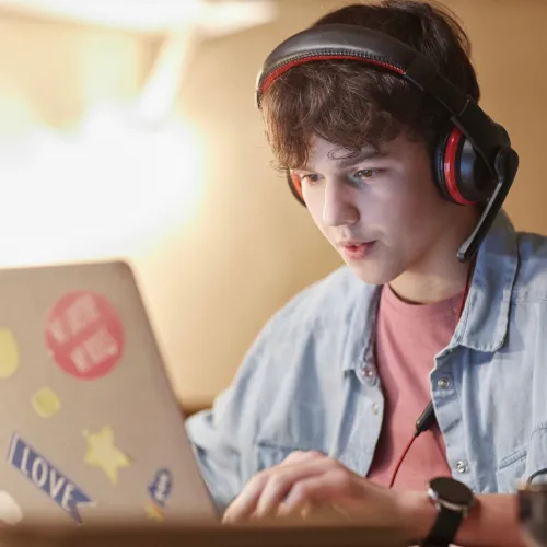 Boy playing games on his laptop.