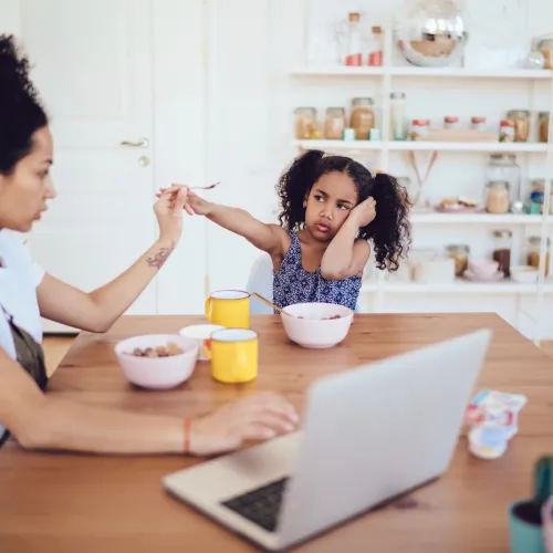 Upset daughter eating breakfast with mom. 