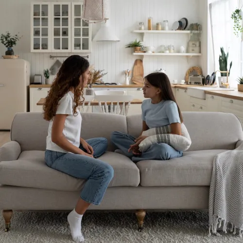 Mom and daughter serious talk on couch.