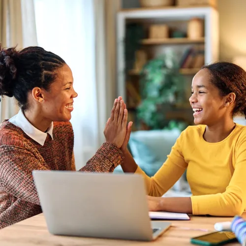 Woman helping young girl with her homework.