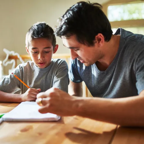 Dad helping young son with homework.