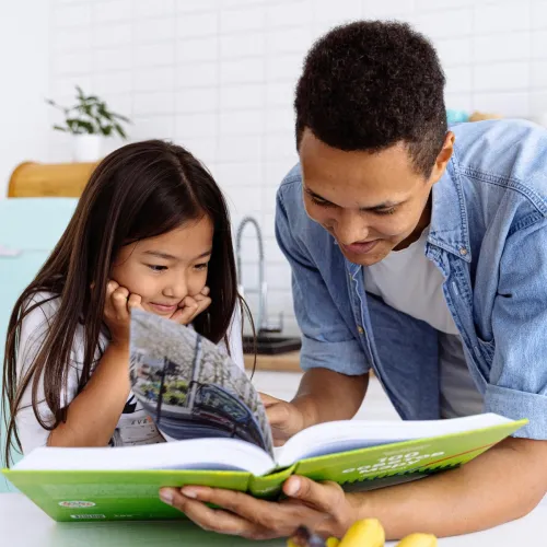 Dad and daughter reading a book.