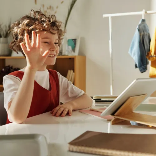 Child on a video call, waving