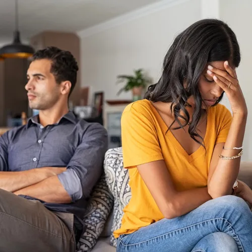 Man and woman arguing in living room.