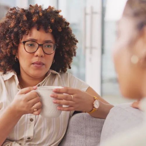 Two women talking seriously on couch