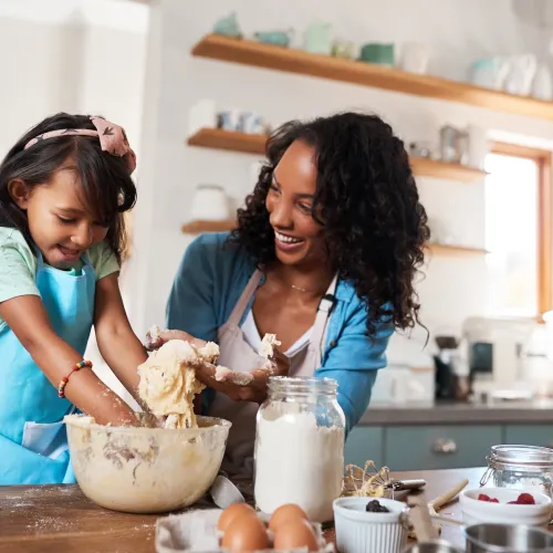 Mom and young daughter baking in the kitchen.