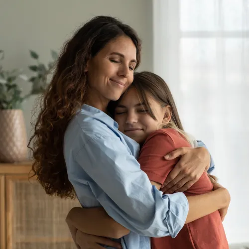 Mom and daughter hugging at home. 