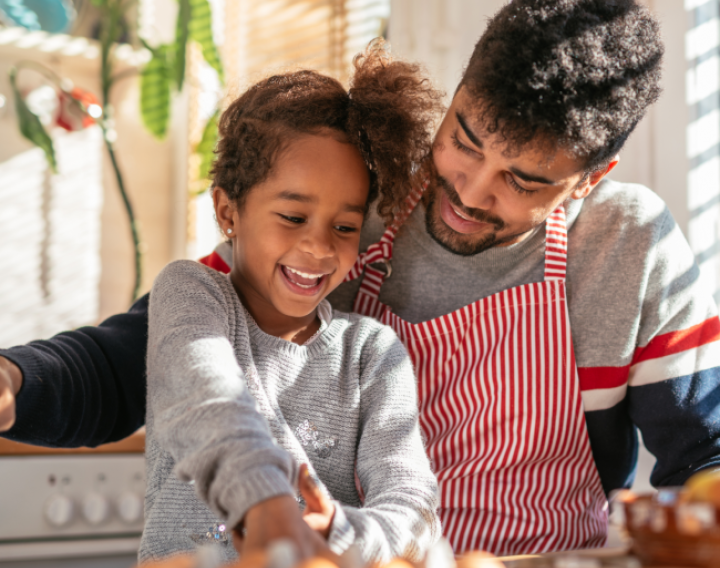 Dad and daughter cooking in kitchen.