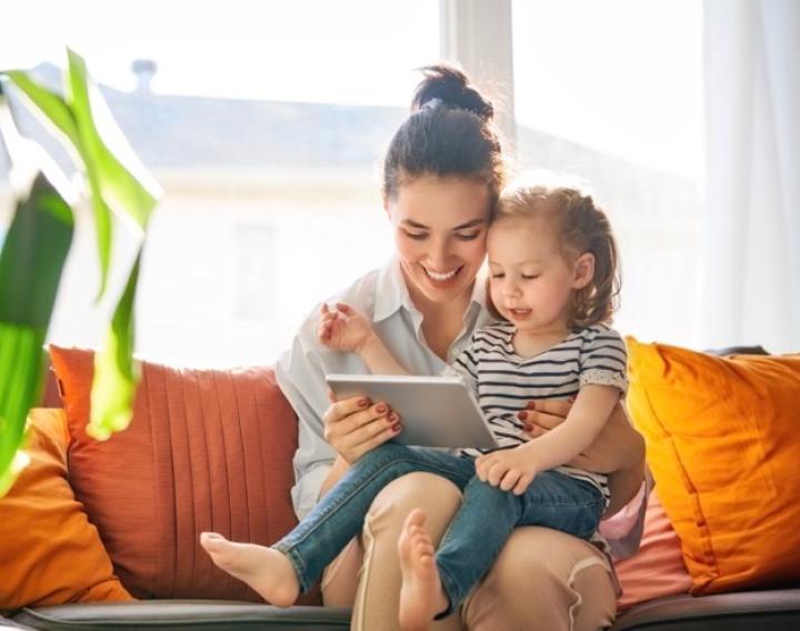 Mother and daughter looking at a tablet, smiling.