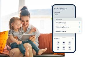 A mother and baby look at OurFamilyWizard on a mobile device