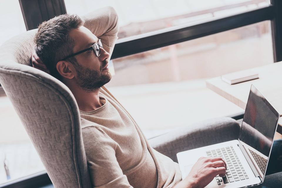 Parent thinking while communicating with co-parent on laptop