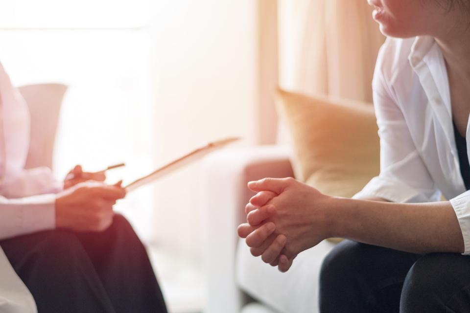 Woman speaks to custody evaluator on couch during a home visit