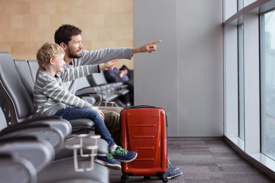 Father and child sit together at the airport.